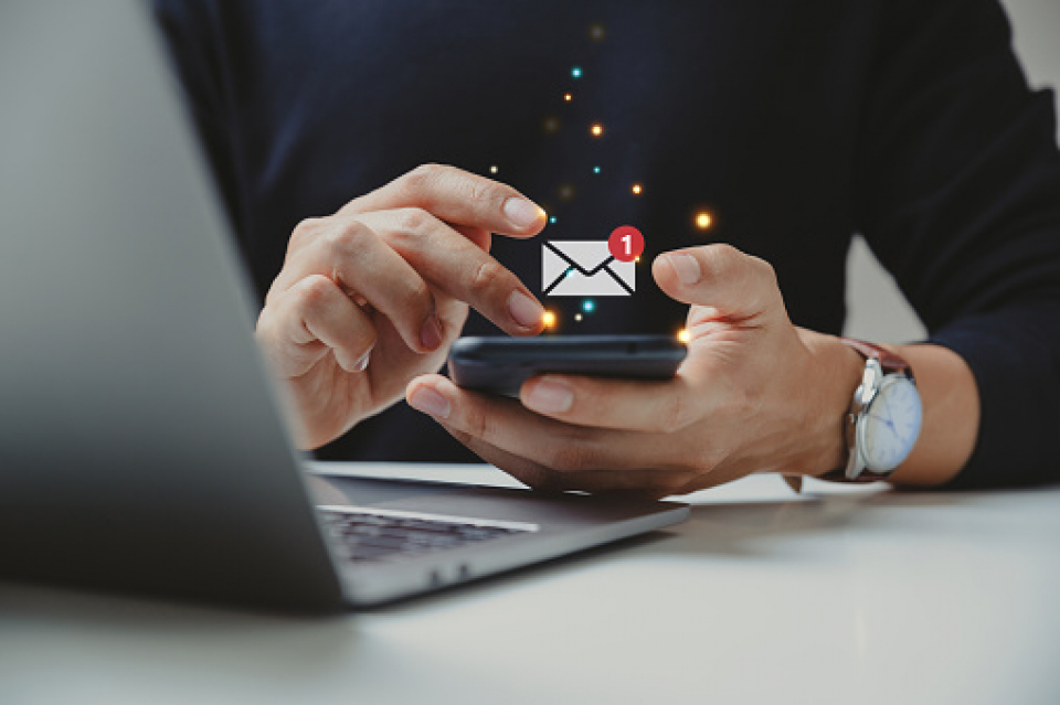 uomo con smartphone in mano che guadagna con email e newsletter facendo email marketing