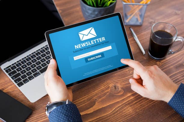 persona con tablet con scritto newsletter per mentere i contatti con i clienti